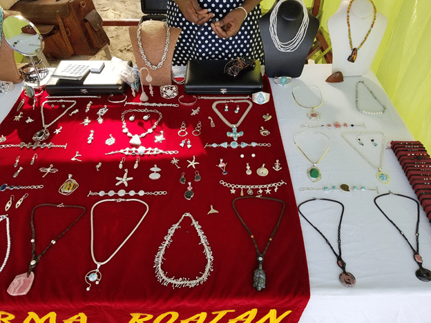 Tables covered with cloths and pieces of jewelry - necklaces, earrings, are laid out on the table for display.