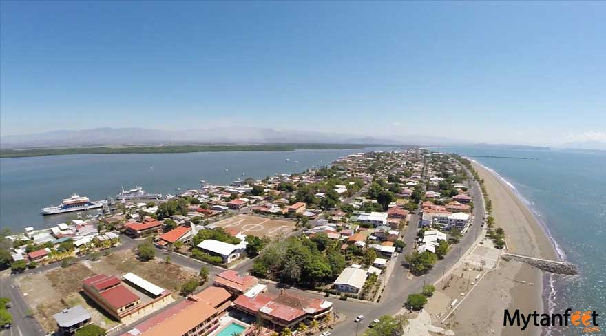 Ariel view of Puntarenas with a road encircling the peninsula, water on both sides, with buildings and trees filling the space.