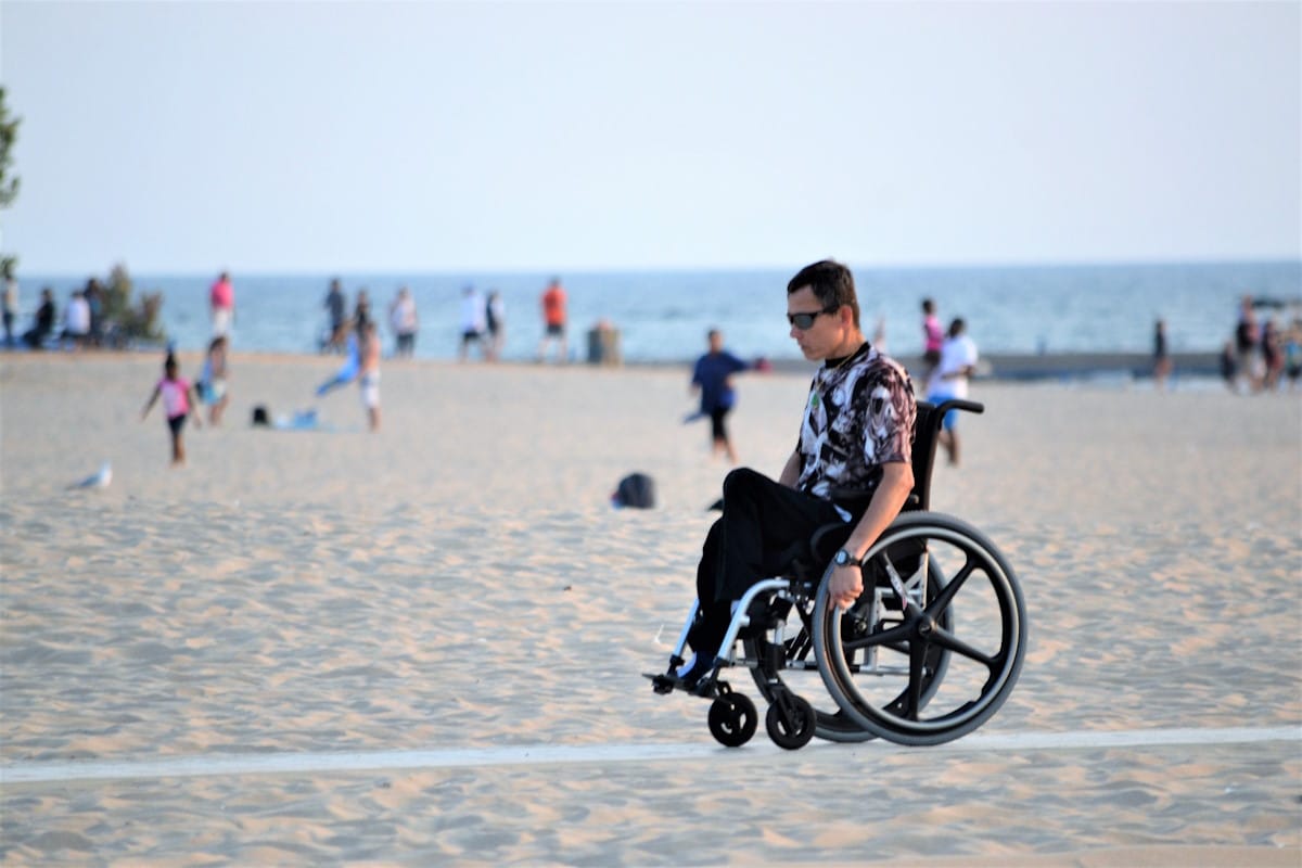 Man in a wheel chair on a beach