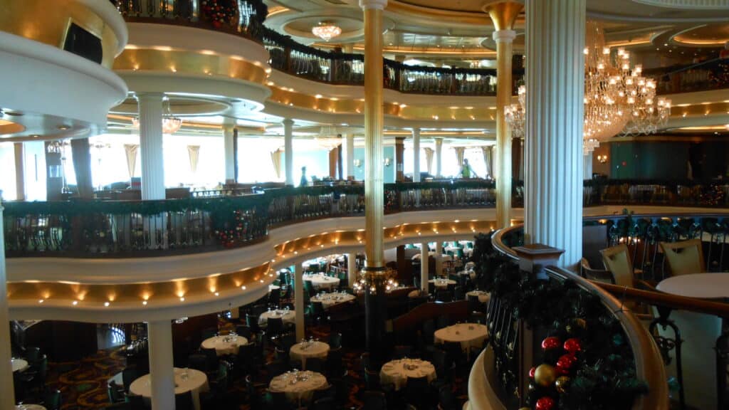 3 level fancy dining room with lots of round tables covered with white table cloths