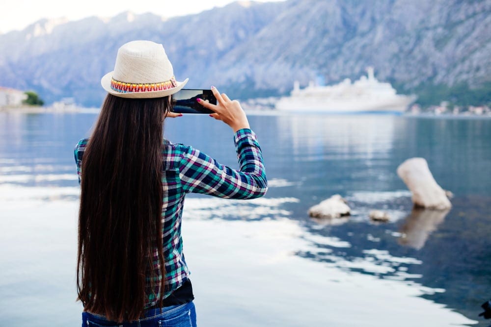 girl taking picture of cruise ship