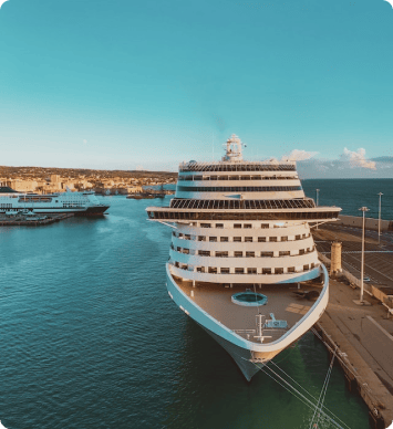 A smaller cruise ship docked at a pier